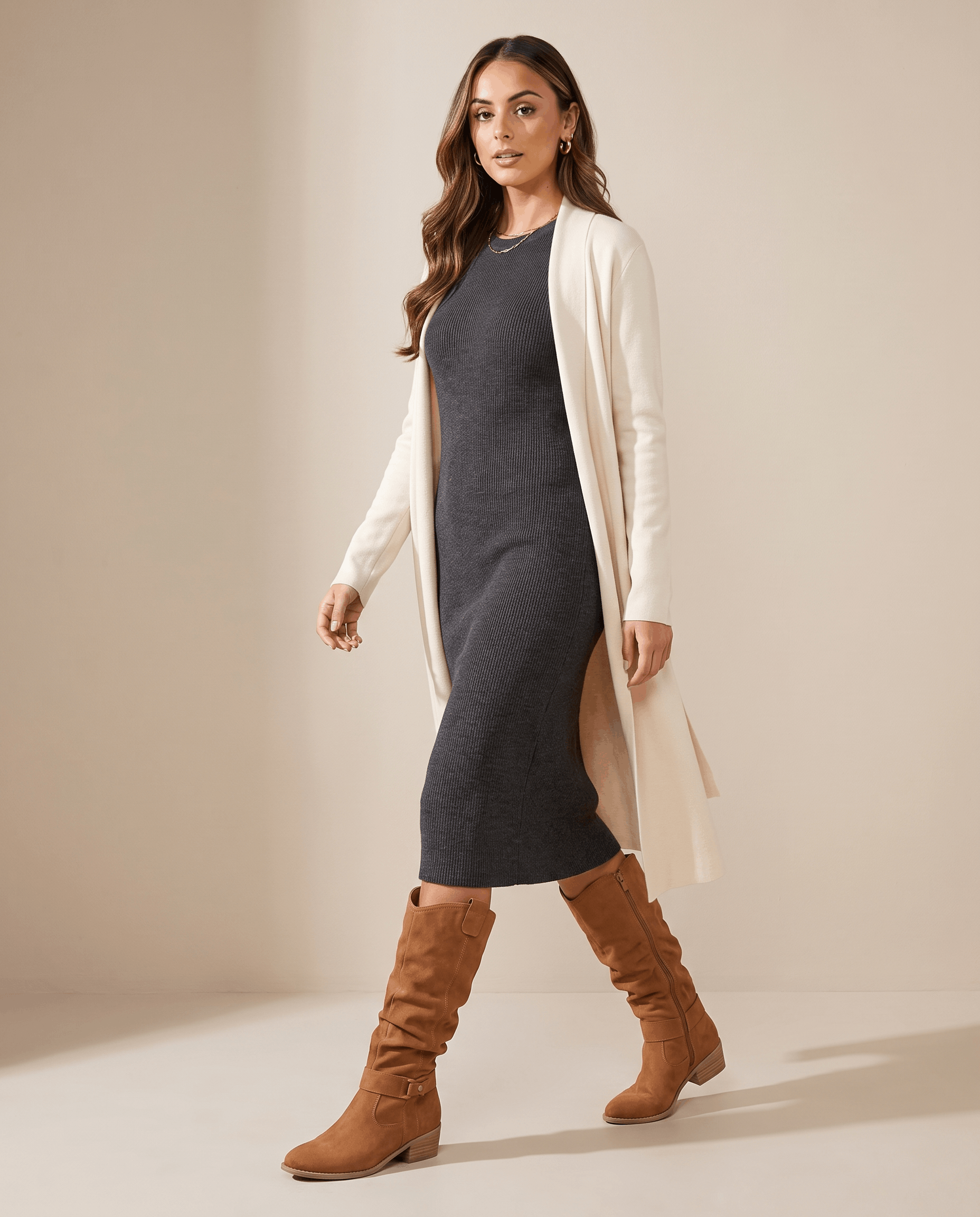 Woman wearing light brown vegan suede knee-high slouch boots with a charcoal knit midi dress and cream cardigan.