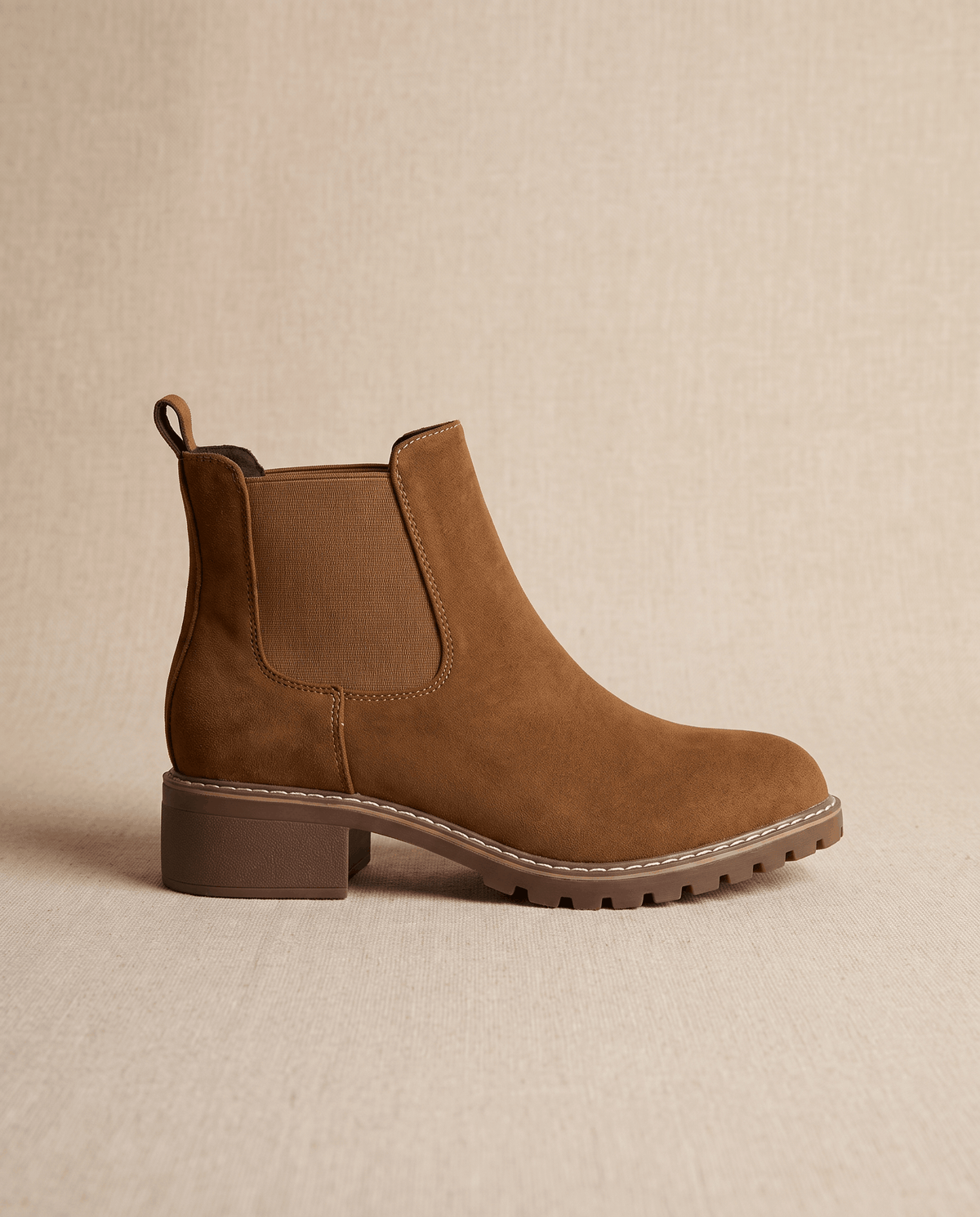 Brown vegan suede Chelsea boot with elastic side panels, a stitched welt, and a sturdy lug outsole block heel.