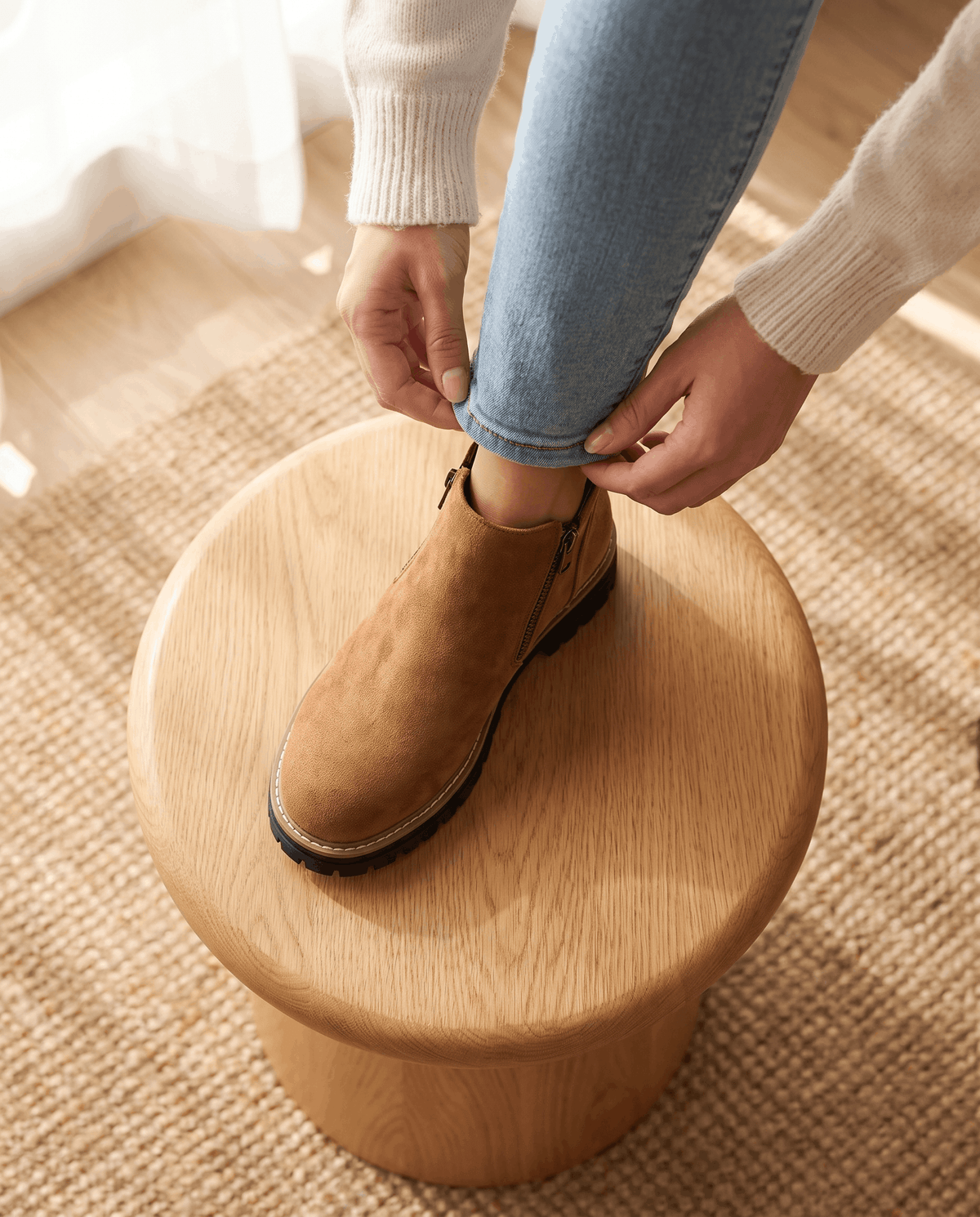 Tan vegan suede ankle boots with side zips and chunky lug platform soles worn with light wash jeans.