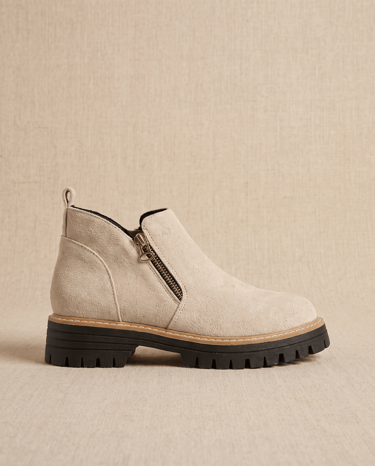 Beige vegan suede ankle boot with a side zip, chunky lug platform, and cushioned wedge sole on a neutral background.