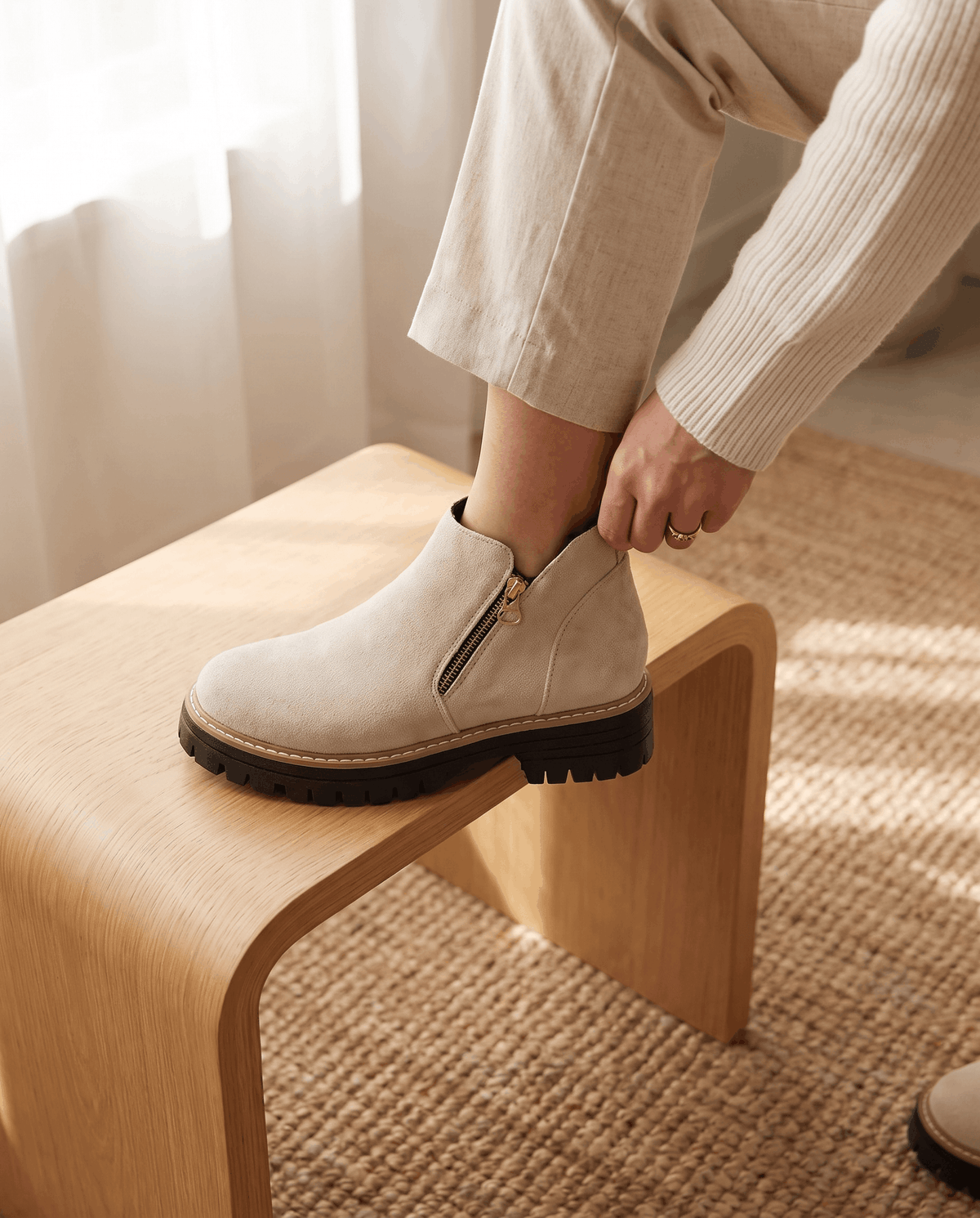 Beige vegan suede ankle boots with a side zip, featuring a chunky lug platform and cushioned wedge sole.