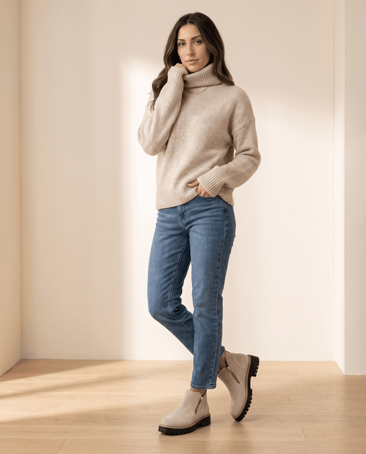 Beige vegan suede ankle boots with side zips and chunky lug platform soles worn with blue jeans and a turtleneck.