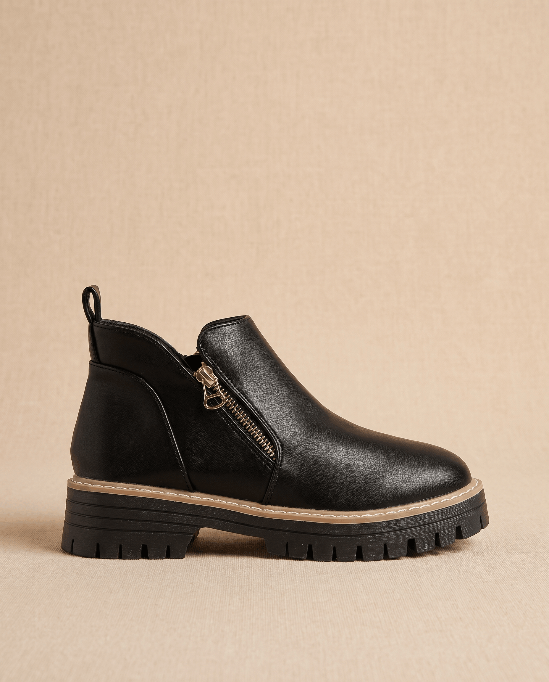 Black vegan suede ankle boots with a matte finish, side zip, and a chunky lug platform wedge sole on a neutral background.