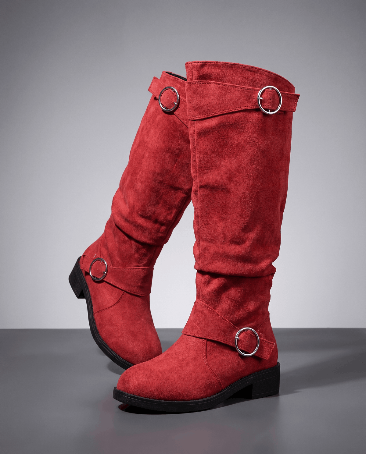 Red vegan suede knee-high boots with a slouched shaft, twin silver ring straps, round toe, and a low stacked heel.