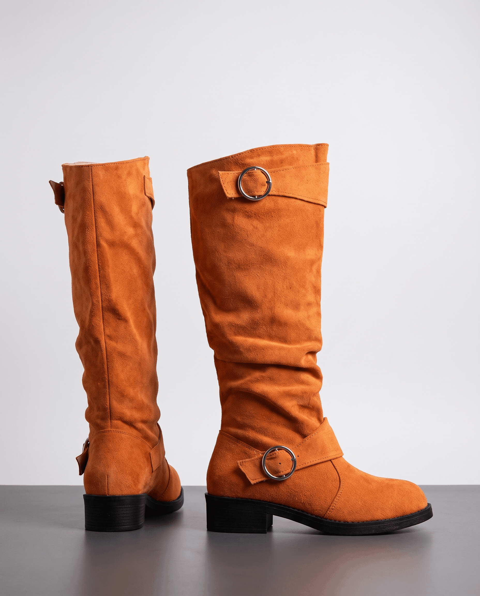 Orange vegan suede knee-high boots with a slouched shaft, twin ring straps, round toe, and a low stacked heel.
