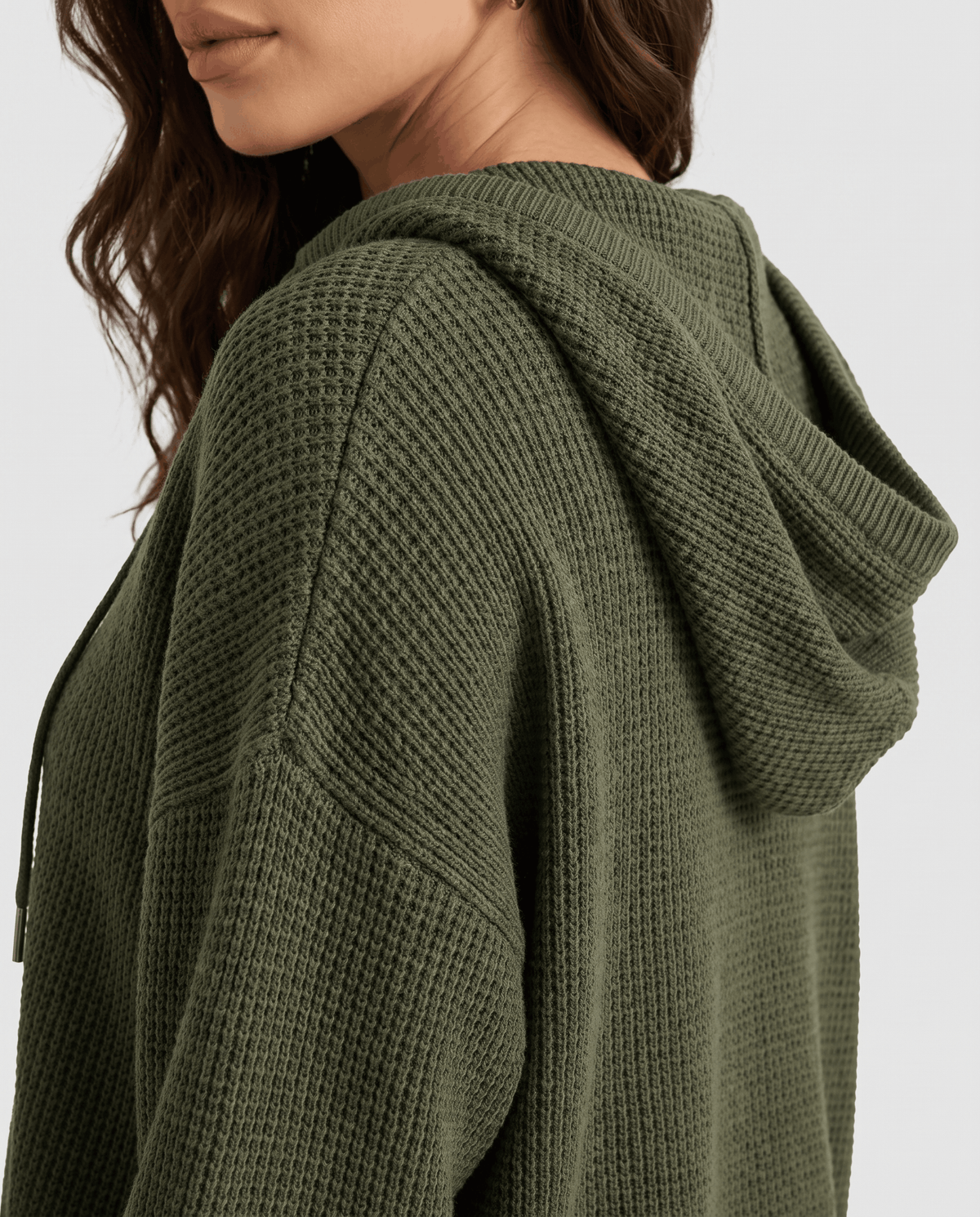 Side close-up of the army green hood and chunky waffle knit sleeve