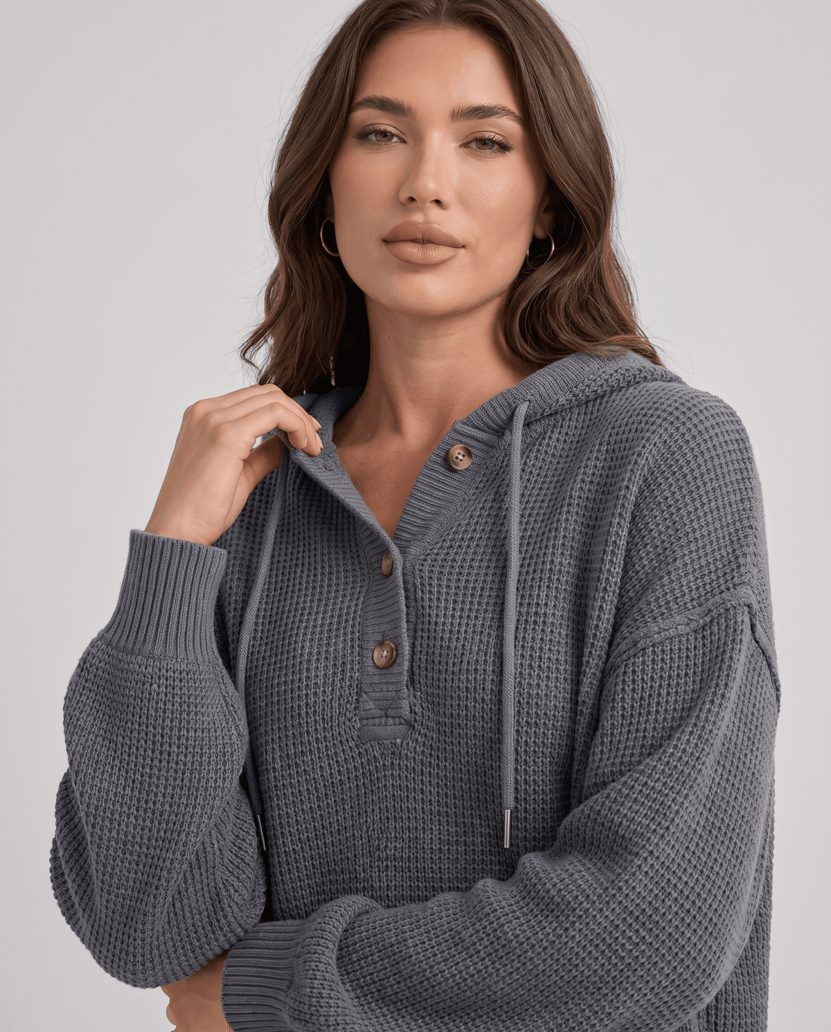 Close-up of the gray hoodie buttoned neckline, drawstrings and ribbed cuff