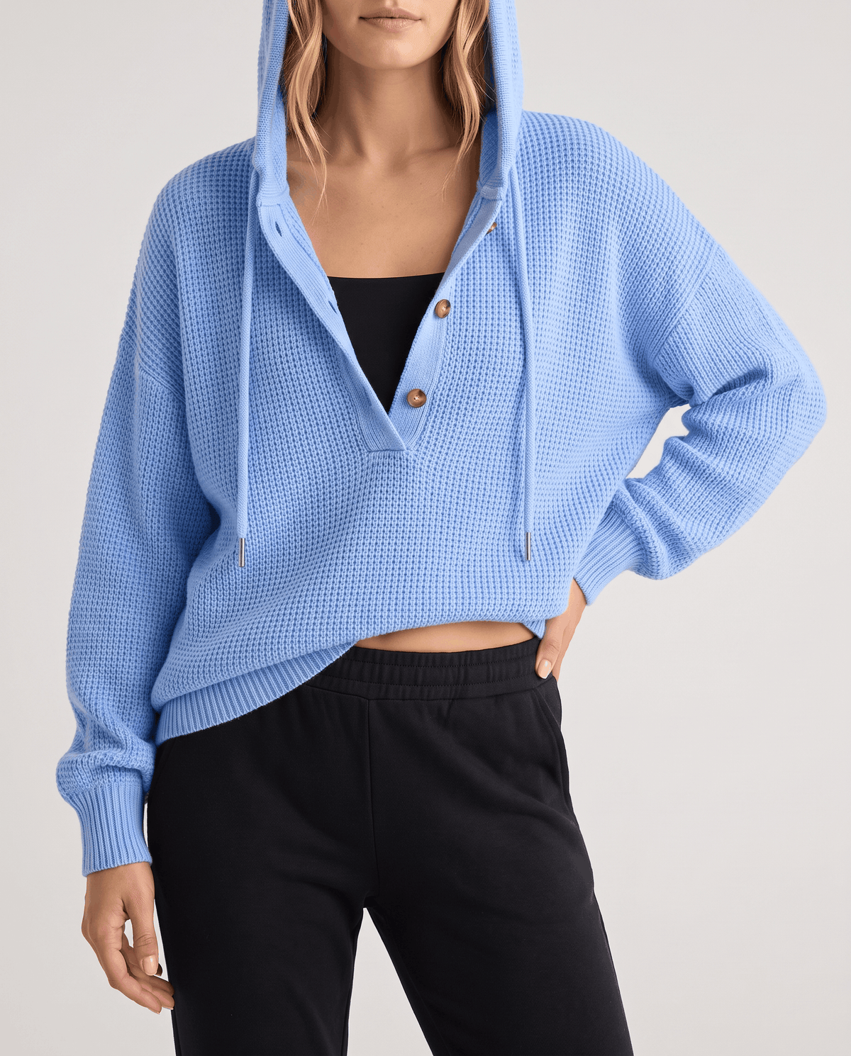 Light blue waffle knit hoodie worn with black pants and a hand on the hip, front view