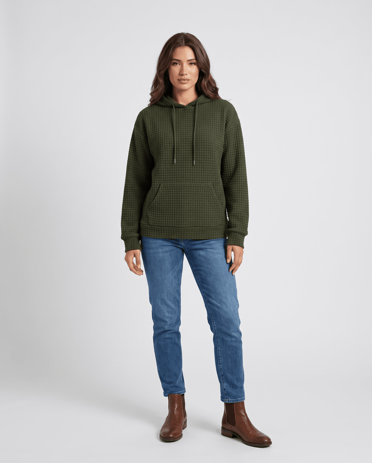 Full-length dark green hoodie styled with blue jeans and brown boots