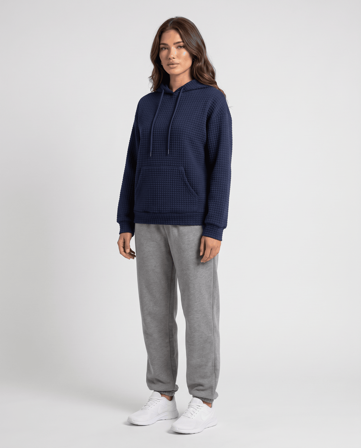 Full-length navy blue hoodie styled with gray joggers and white sneakers