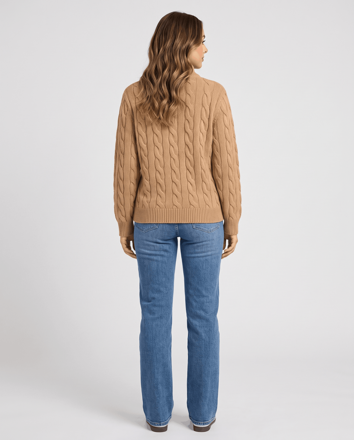 Back view of camel cable-knit sweater with straight blue jeans