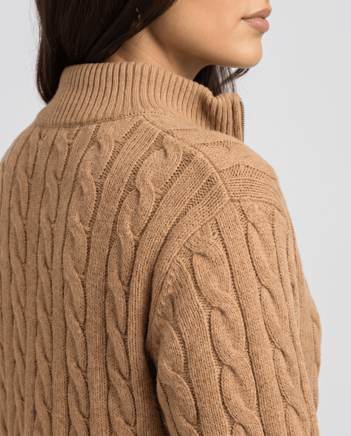 Rear shoulder detail of camel sweater showing the raised cable knit