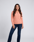 Woman in coral wool-blend cable-knit half-zip sweater with blue jeans