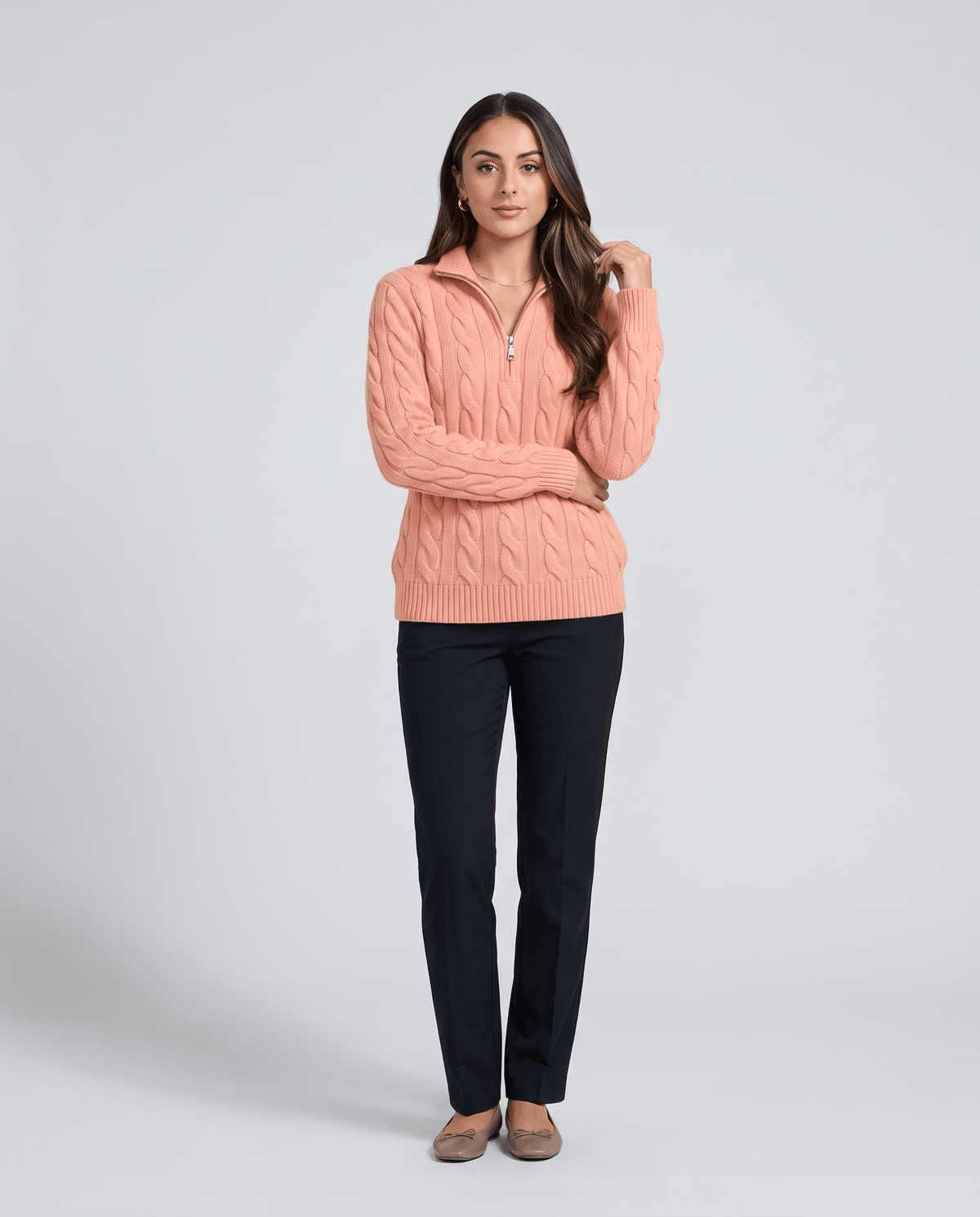 Full-length view of coral sweater with black trousers and flats