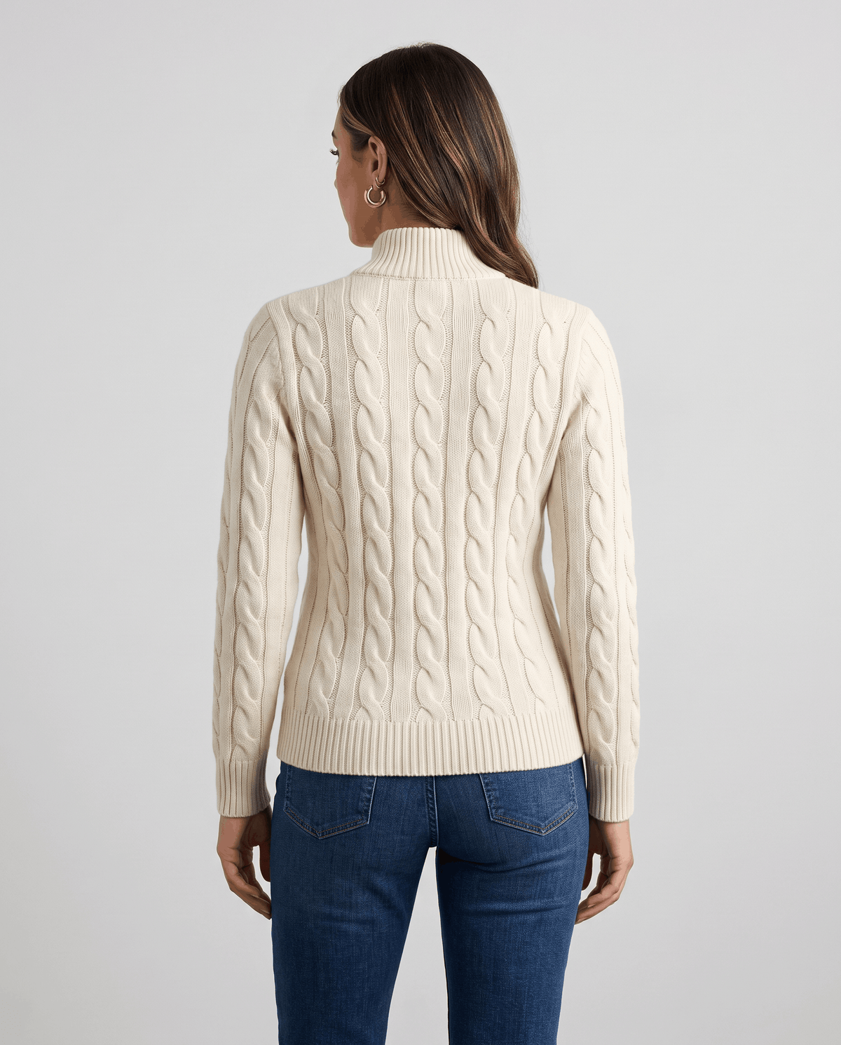 Back view of cream cable-knit sweater with blue jeans