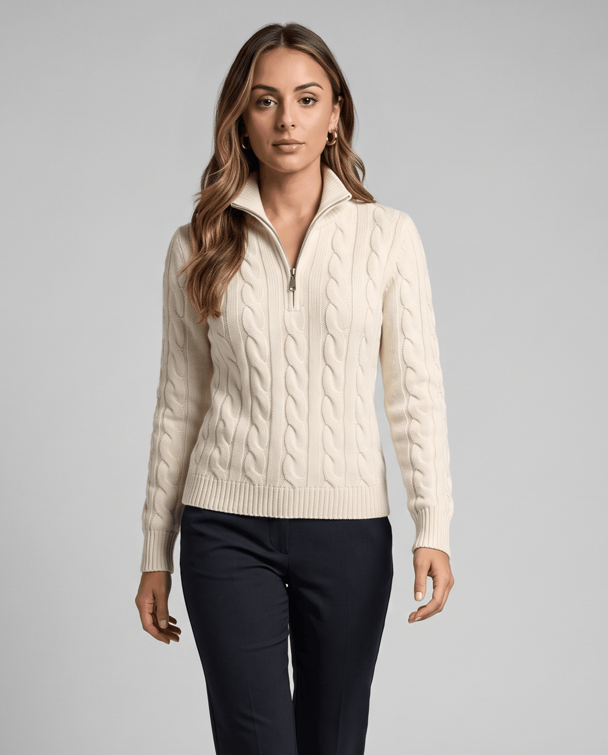 Woman in cream cable-knit half-zip sweater with navy trousers