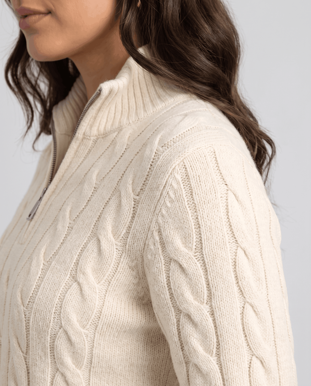 Side detail of cream sweater collar and cable-knit shoulder