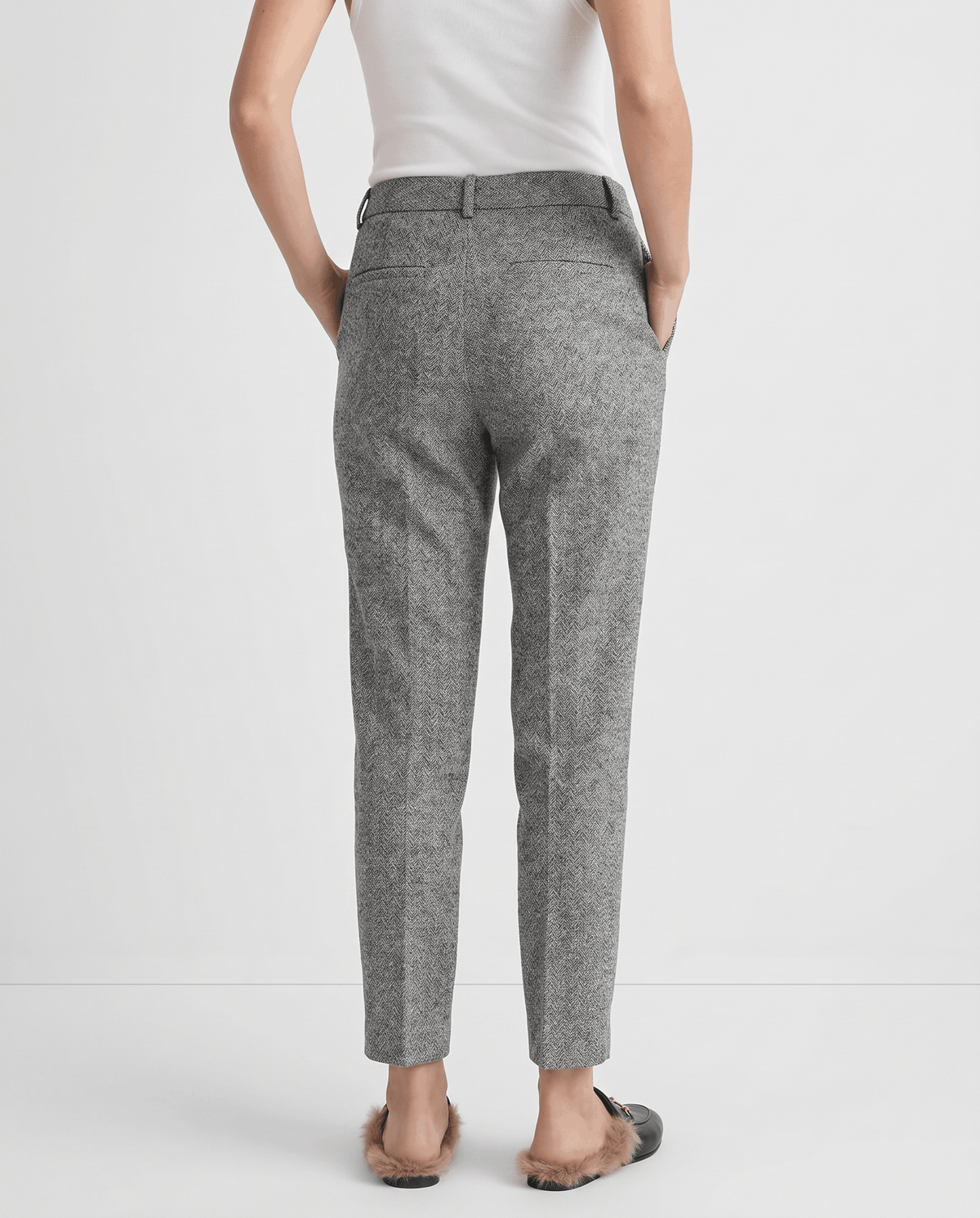 Back view of gray ankle-length trousers with flat mules