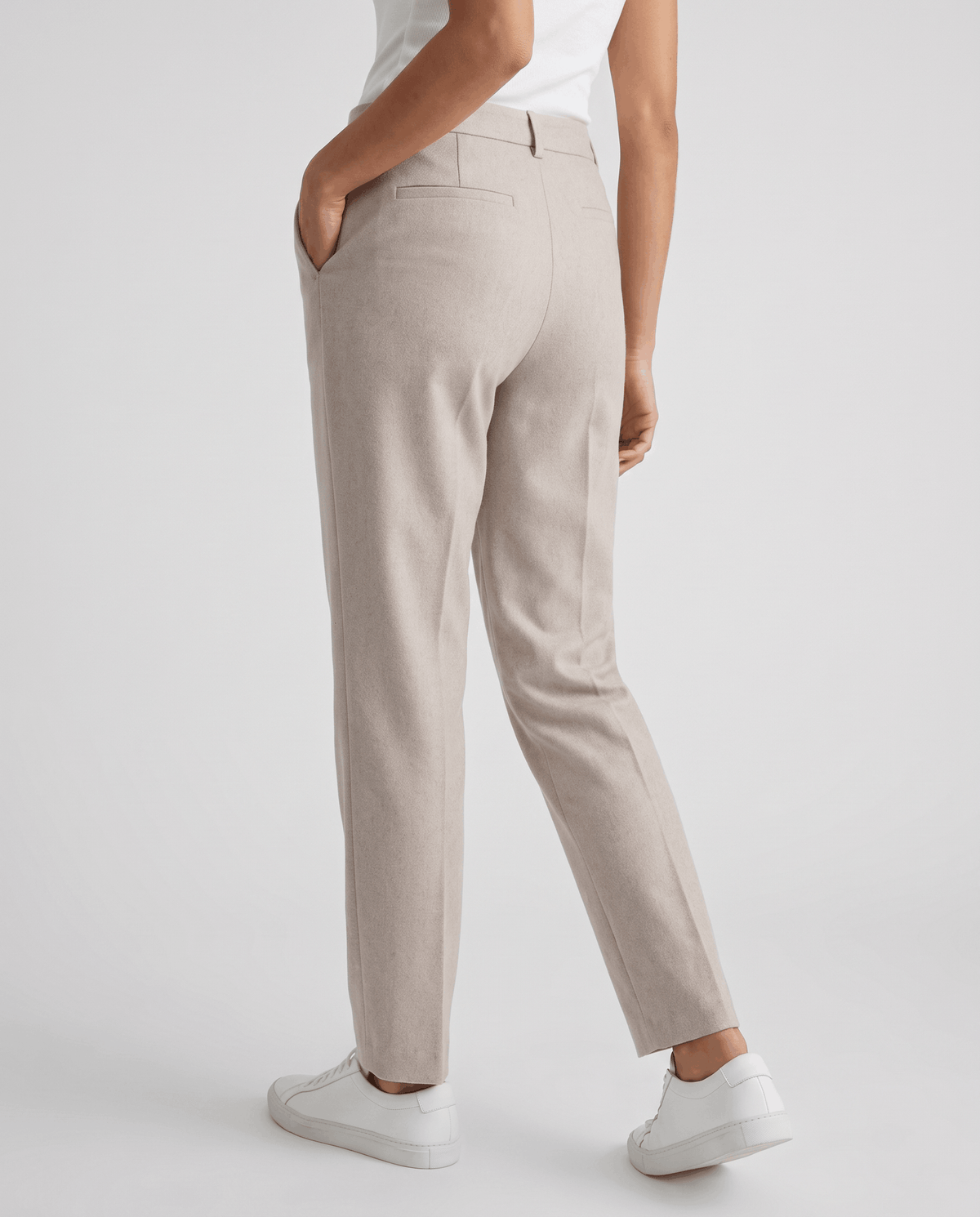 Back view of ivory straight-leg trousers with hand in pocket