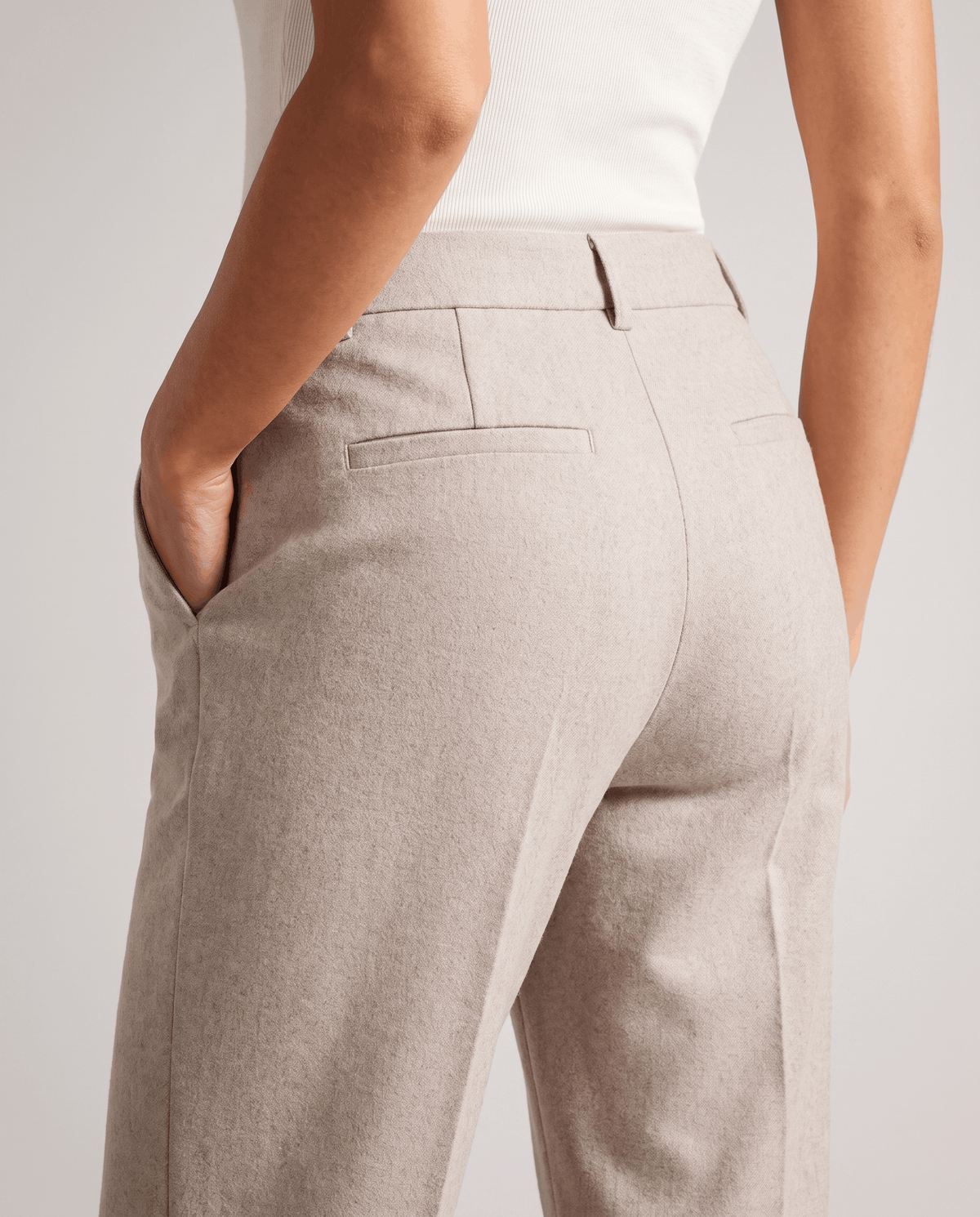 Back detail of ivory trousers showing twin welt pockets and belt loops