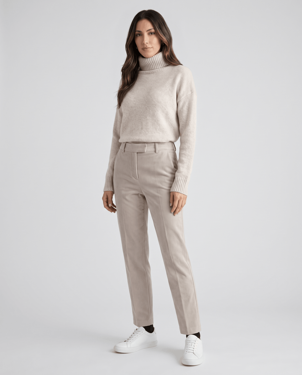 Model in cream turtleneck and matching ivory straight-leg trousers