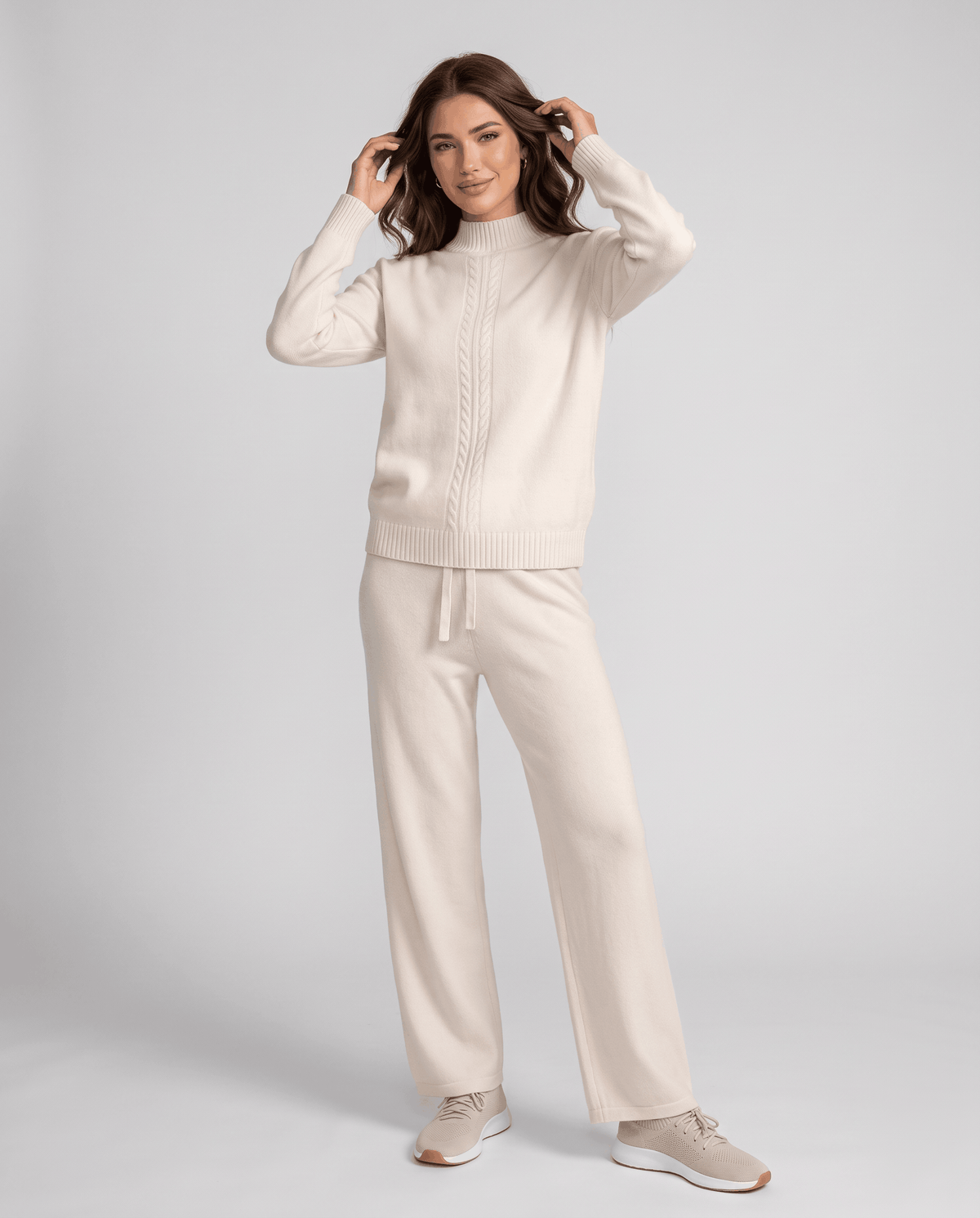 Beige wool mock-neck pullover and straight-leg pants loungewear set, front view with hands at head