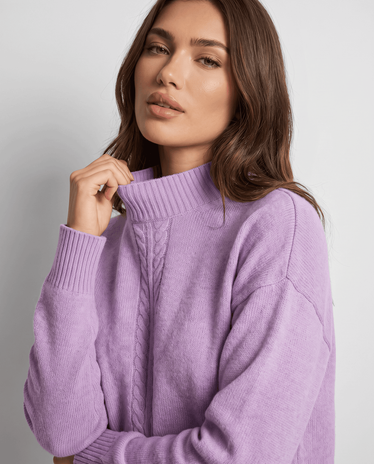 Close-up of the mock neck and ribbed cuff on the purple knit pullover