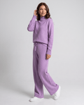 Woman wearing a purple wool mock-neck cable knit pullover and straight-leg pants loungewear set, walking front view