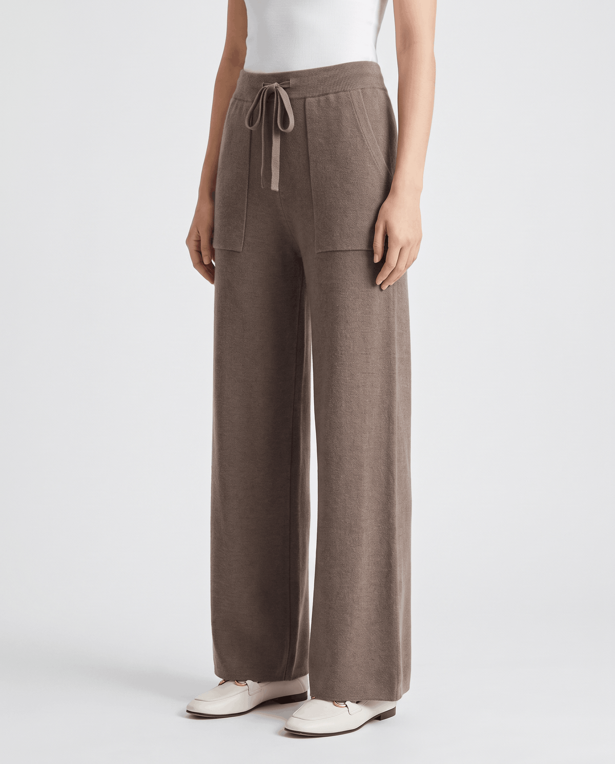 Taupe-beige knit pants in three-quarter front view with contrast drawstring