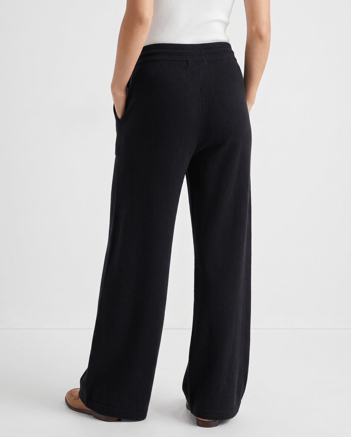 Back view of black wide-leg pants falling to the floor