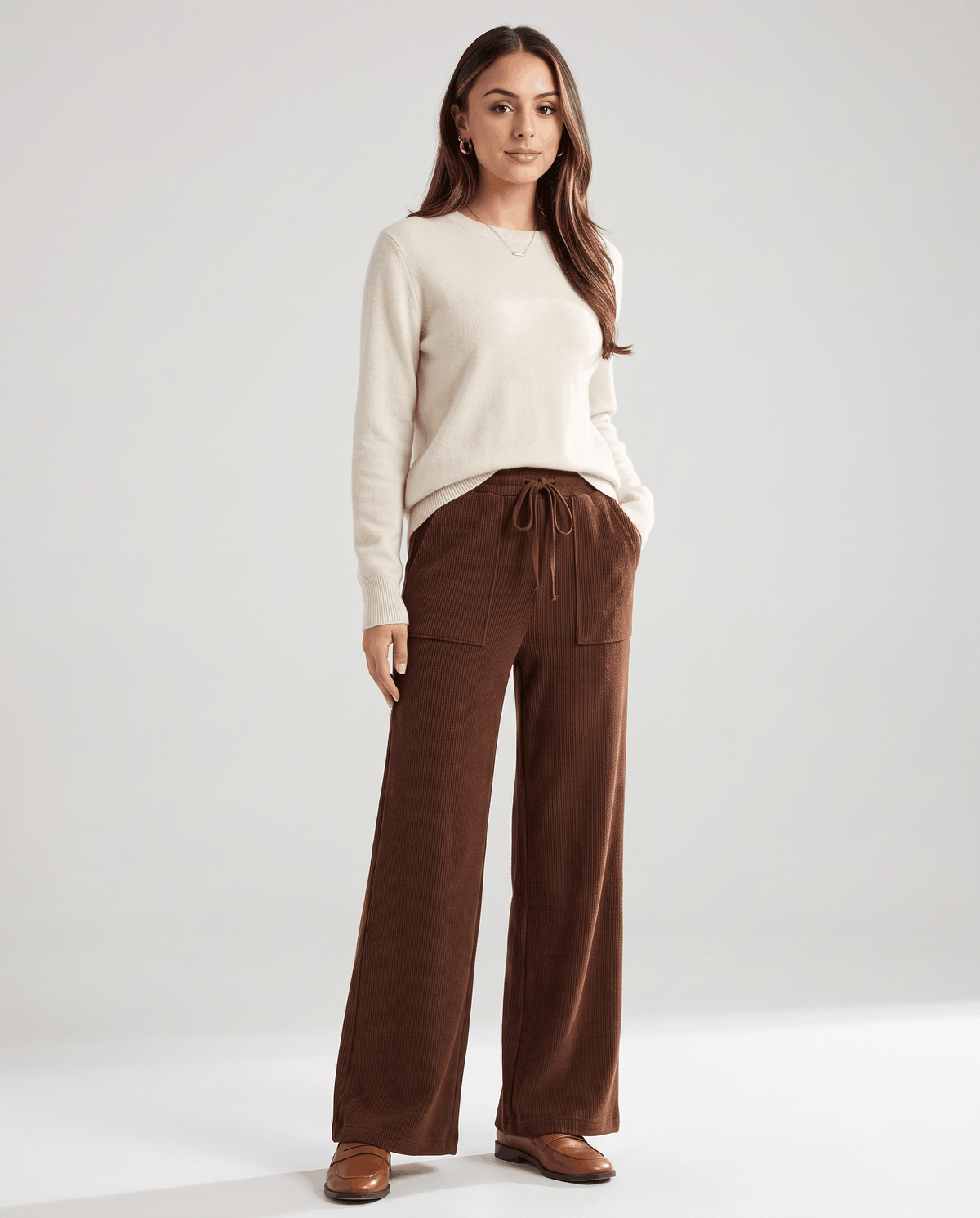 Model in cream sweater and brown high-waisted knit pants