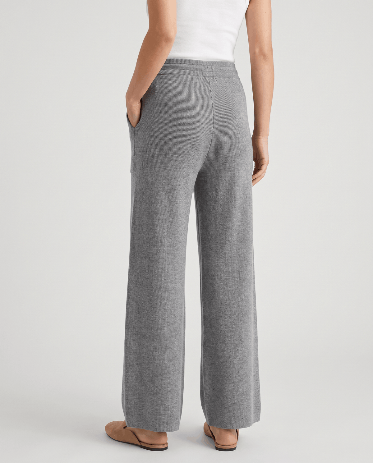 Back view of gray full-length wide-leg pants with tan sandals