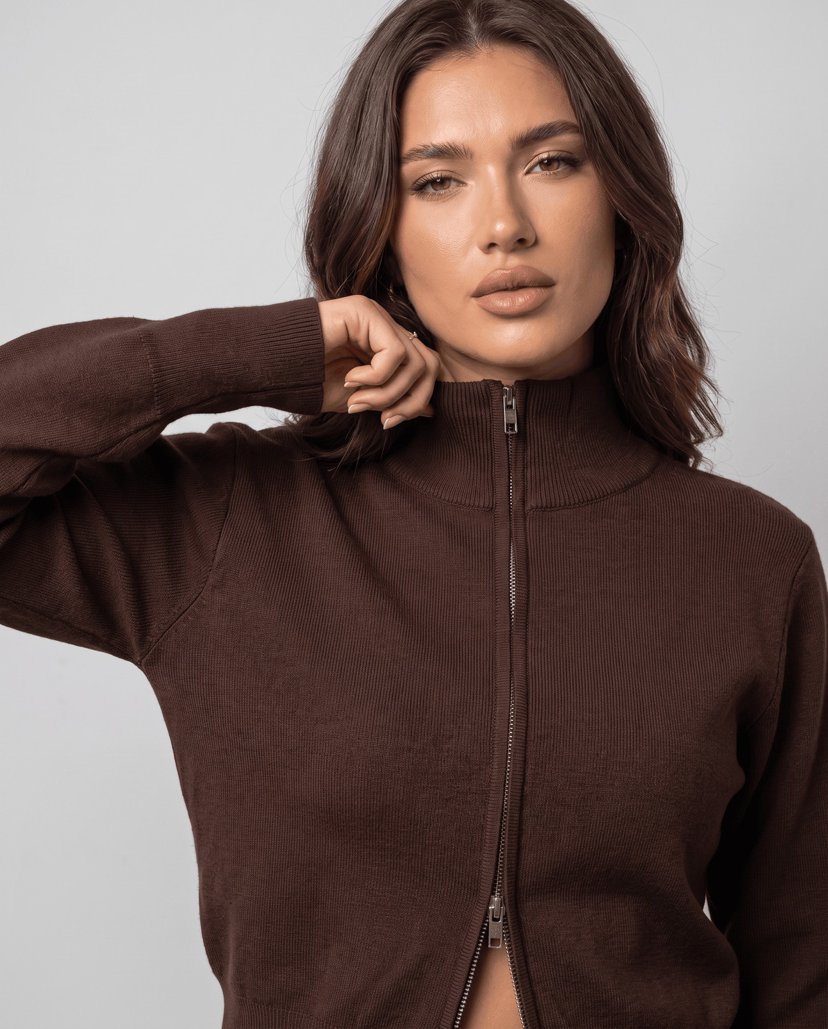 Close-up of the front zip and knit texture on the brown cardigan