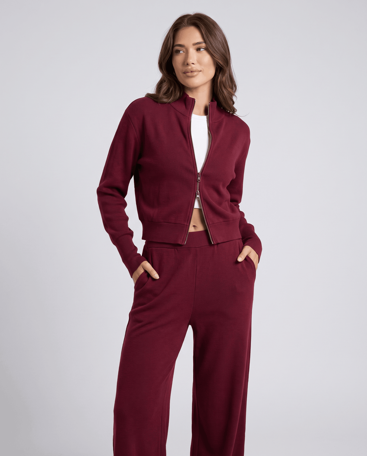 Burgundy knit cardigan lounge set, three-quarter view with hand in pocket