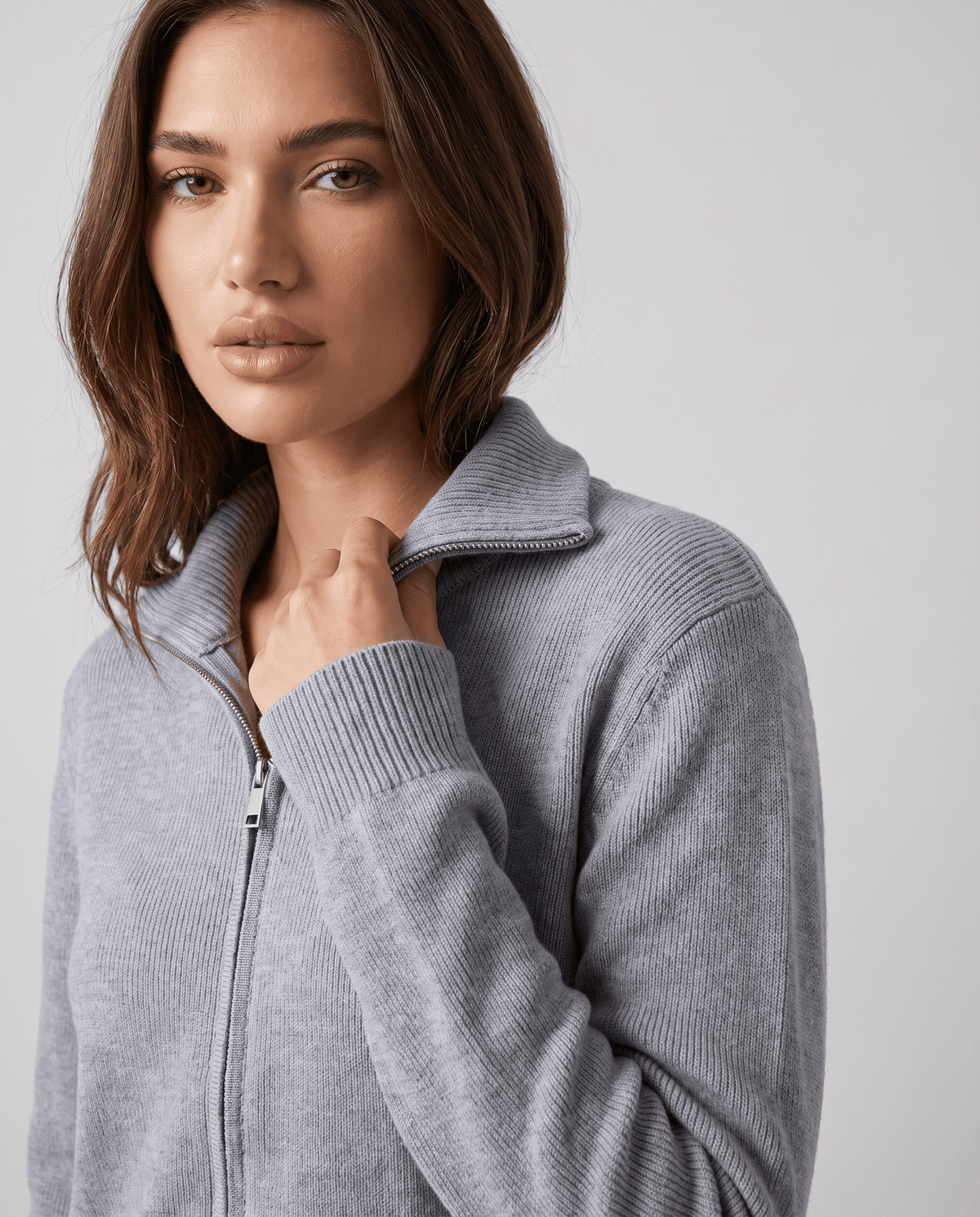 Close-up of the zip, collar and ribbed cuff on the gray knit cardigan